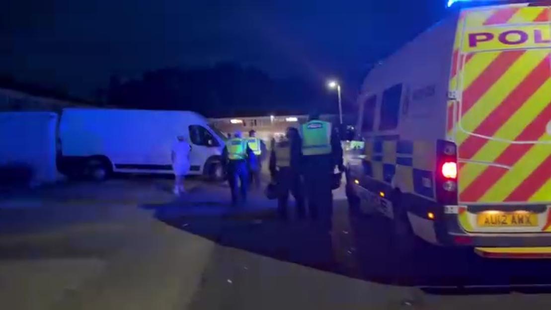 Police officers escorting individuals to safety at night in Thetford.