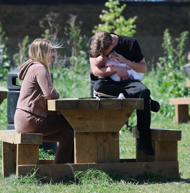 Freddy Brazier feeding baby Isla while Holly Swinburn watches.
