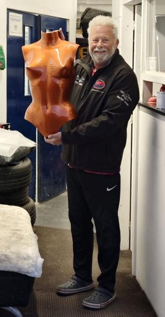 Martyn Smith holding the orange fibreglass breastplate he painted for Kim Kardashian's Met Gala outfit.