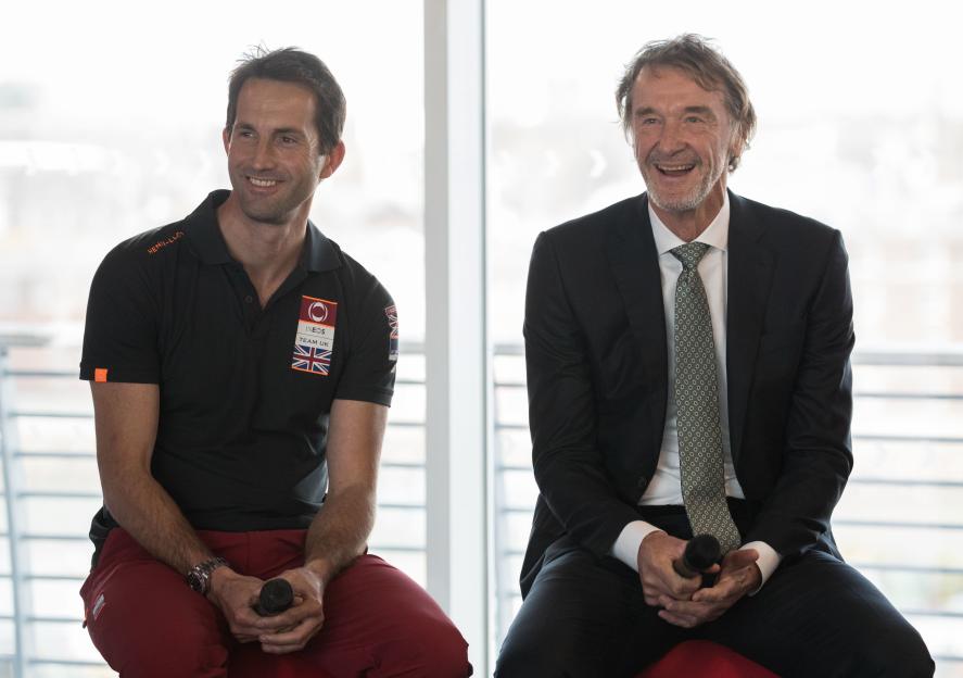 Sir Ben Ainslie and Sir Jim Ratcliffe smiling at the launch of the Ineos Team UK America's Cup boat 'Britannia'.