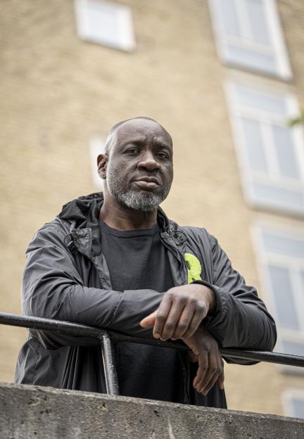 Essa Sallah Kah, a reformed gangster, leans on a railing.