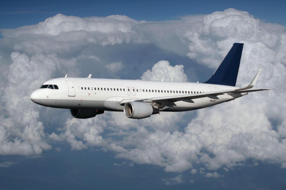 Airbus A320 passenger jet flying above clouds.