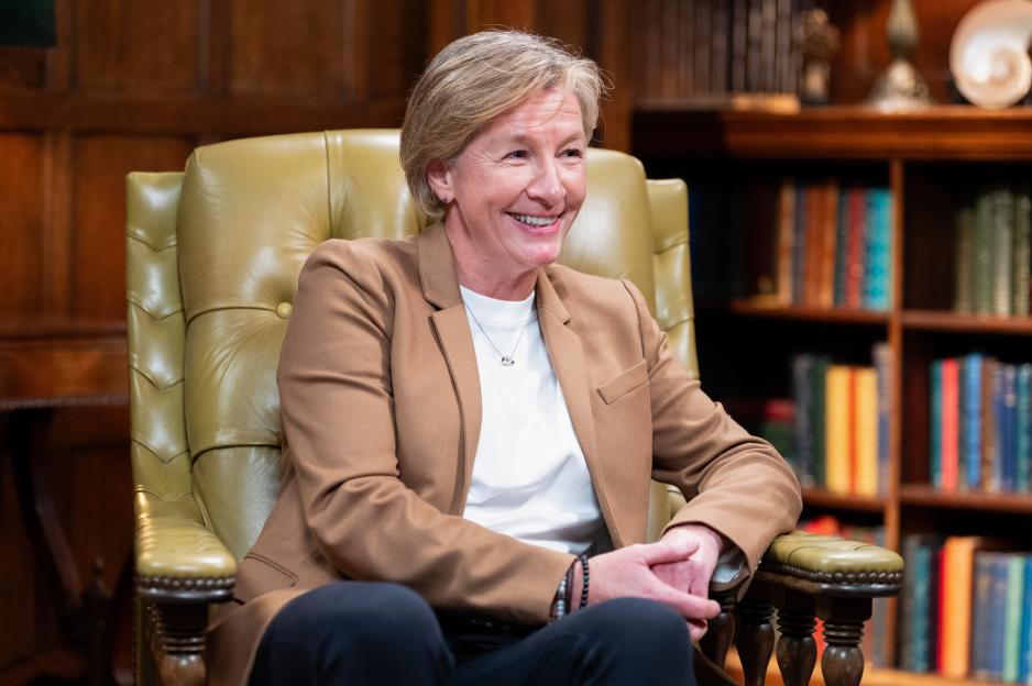 Amanda smiling while sitting in a green leather chair.