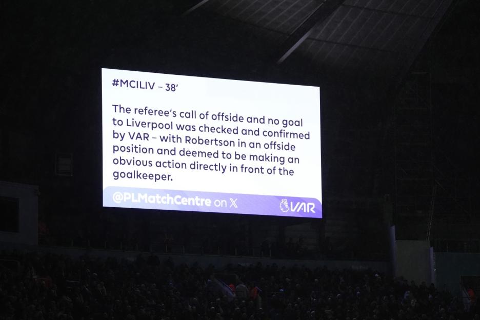 Jumbotron displaying a VAR decision confirming an offside call against Liverpool during a Manchester City vs. Liverpool Premier League match.