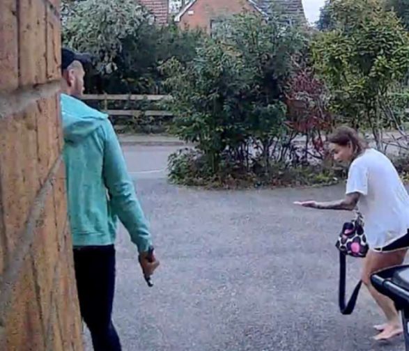 Christopher Gillham holding a hammer while walking behind Sarah Tragner.