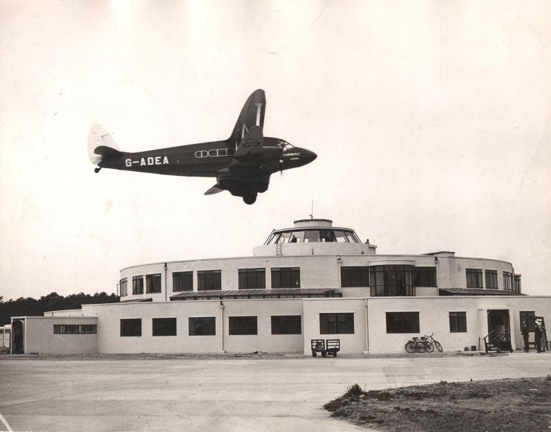A de Havilland DH86 Express Air Liner, G-ADEA, of British Airways, flies past the Beehive terminal building at Gatwick Airport in 1937.