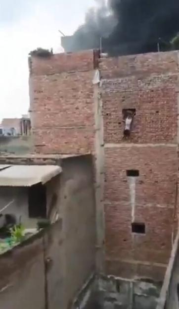 Moment people jump from third-floor window as factory goes up in flames & six including 3 kids rushed to hospital
