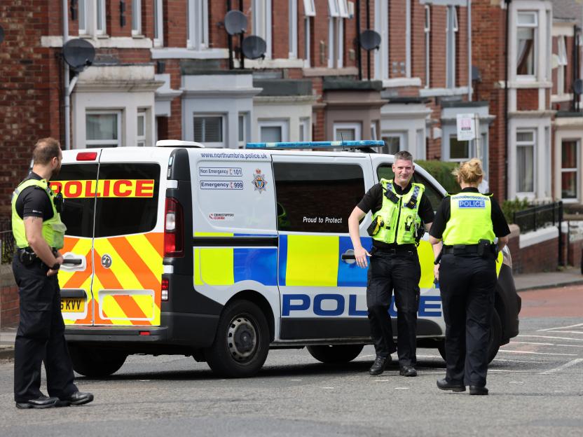 Three police officers standing next to a police van.