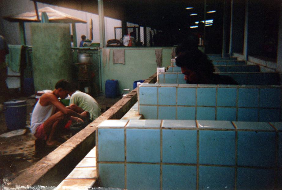 Men cleaning laundry inside a Thai prison.