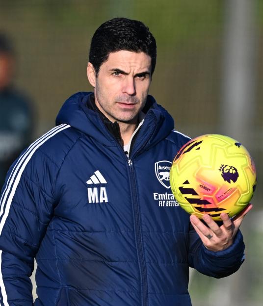 Mikel Arteta holding a football during an Arsenal training session.
