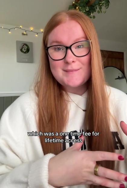 A young woman with red hair and glasses talking, with text overlay.