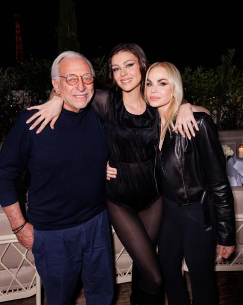 Three people posing together, an older man, a young woman, and a blonde woman.