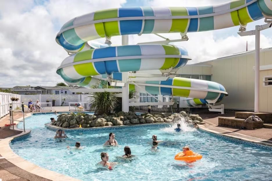 People swimming in a lazy river and a colorful water slide.