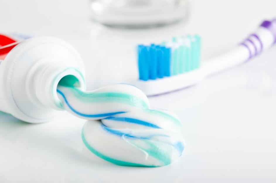 Toothbrush,Tube of toothpaste and a glass in the background,Romania