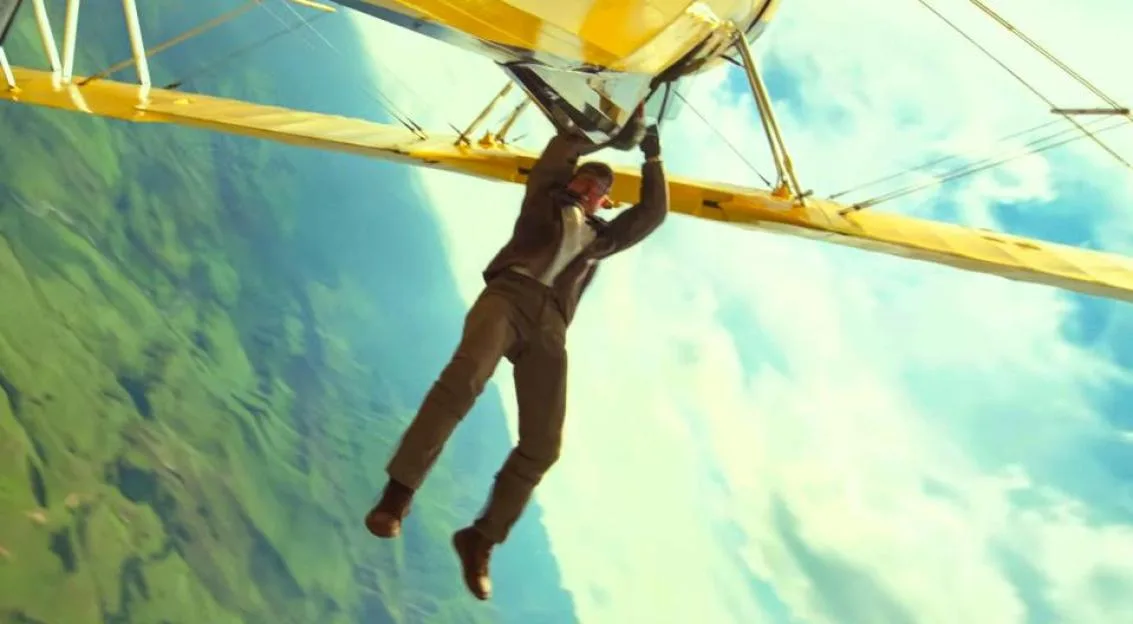 Tom Cruise hangs from the wing of a biplane in a scene from Mission: Impossible - The Final Reckoning.
