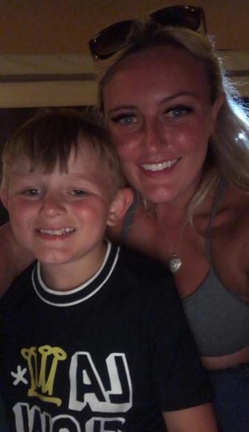 A woman and a young boy smiling at the camera.