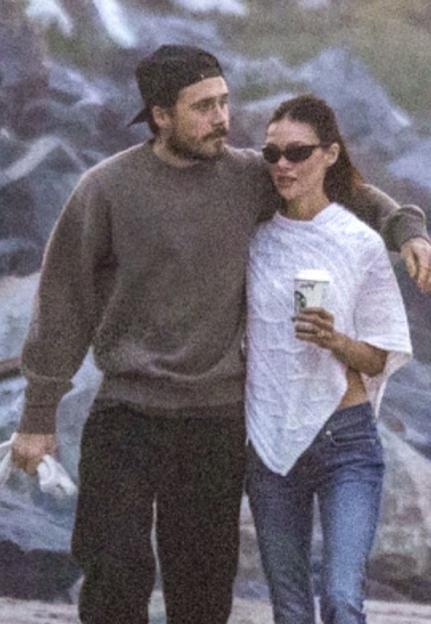 Brooklyn Beckham with his arm around Nicola Peltz Beckham on a beach.