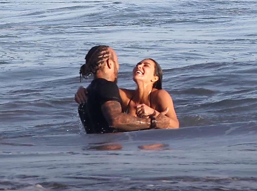 Kim Kardashian and Lewis Hamilton embracing in the ocean.