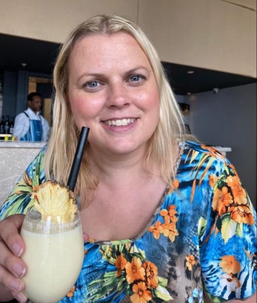 Lois Kinder smiling and holding a cocktail.