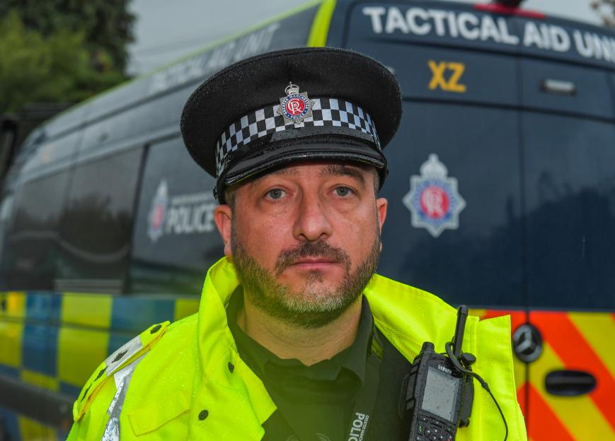 Chief Inspector Lee Gridley, in uniform, with a police van in the background.