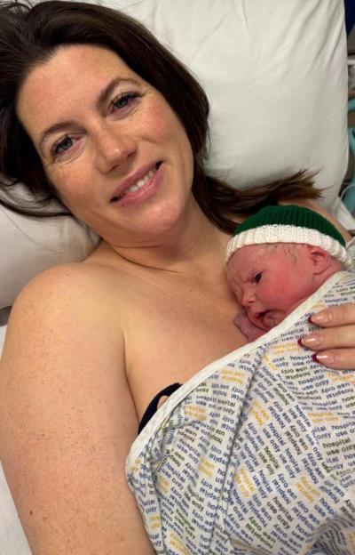 A mother holding her newborn baby in a hospital room.