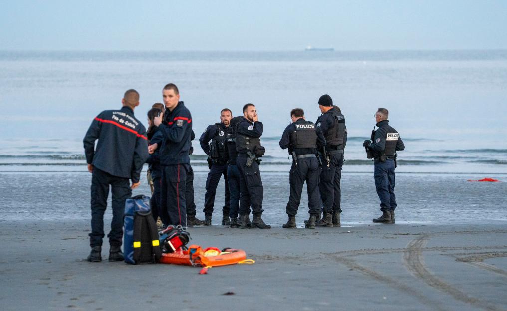 French police and emergency personnel on a beach, with rescue equipment on the sand.