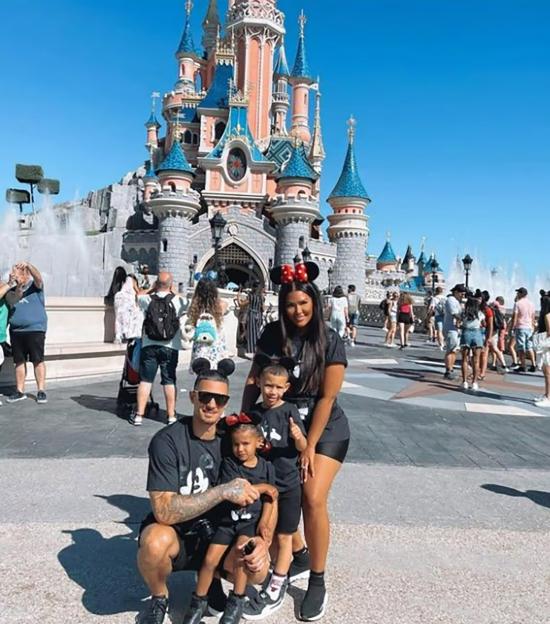 Rochelle Anthony and her family posing in front of Sleeping Beauty Castle at Disneyland.