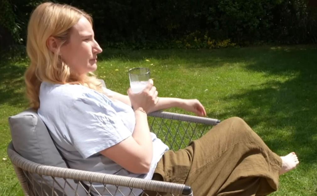 Woman relaxing in a chair in a sunny garden.
