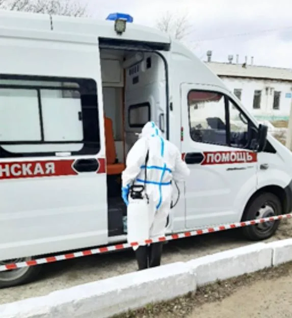 A person in full protective gear stands by an ambulance during a plague-response drill.
