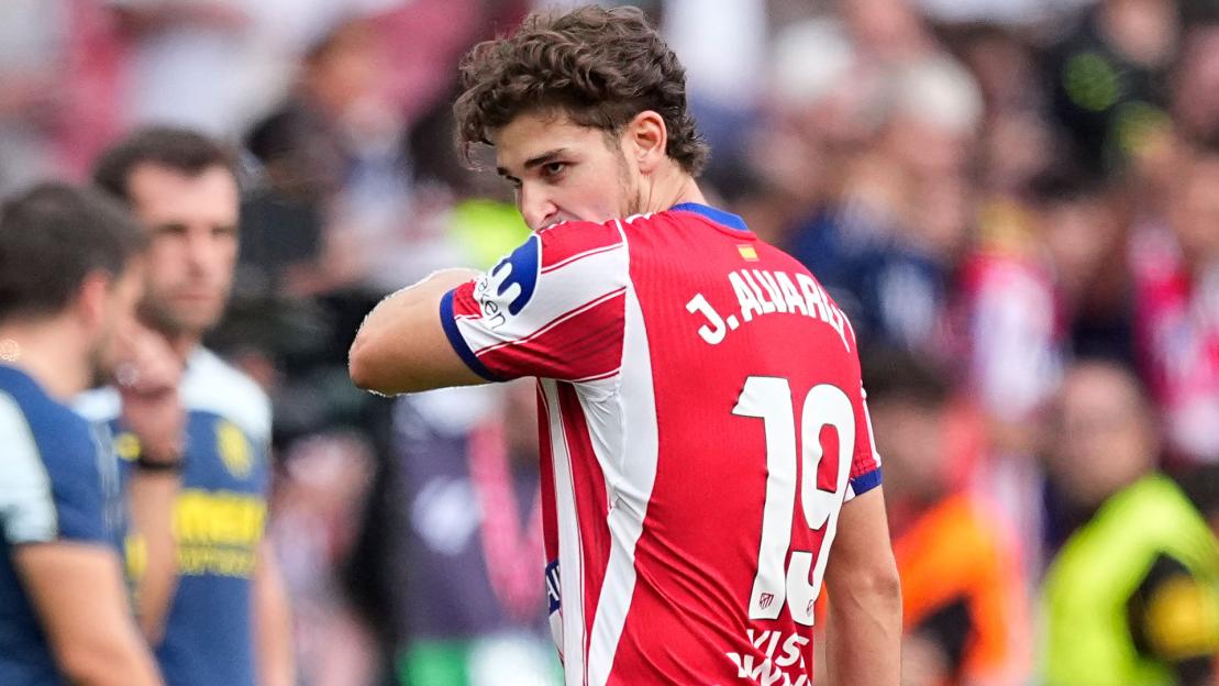 Football player J. Alvarez wiping his face with his jersey.