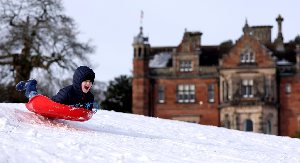 Aidey Sutcliffe sledges down a snowy hill in front of Keele Hall.