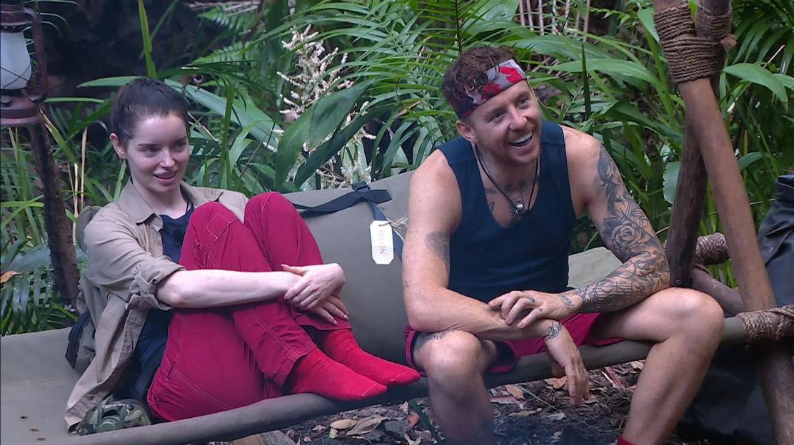 Maura Higgins and Danny Jones sitting in a jungle setting on 'I'm a Celebrity...Get Me Out of Here!'