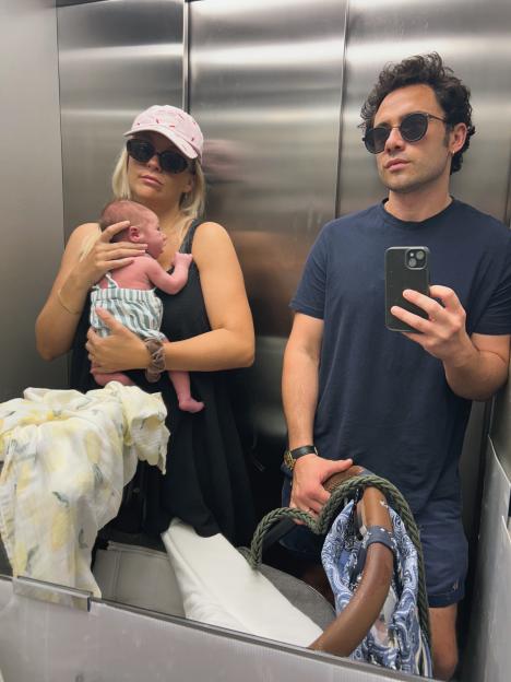 Toby Sebastian takes a mirror selfie with his wife and newborn baby in an elevator.