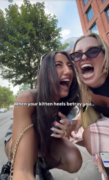 Two women laughing with the text "When your kitten heels betray you..." superimposed on the image.