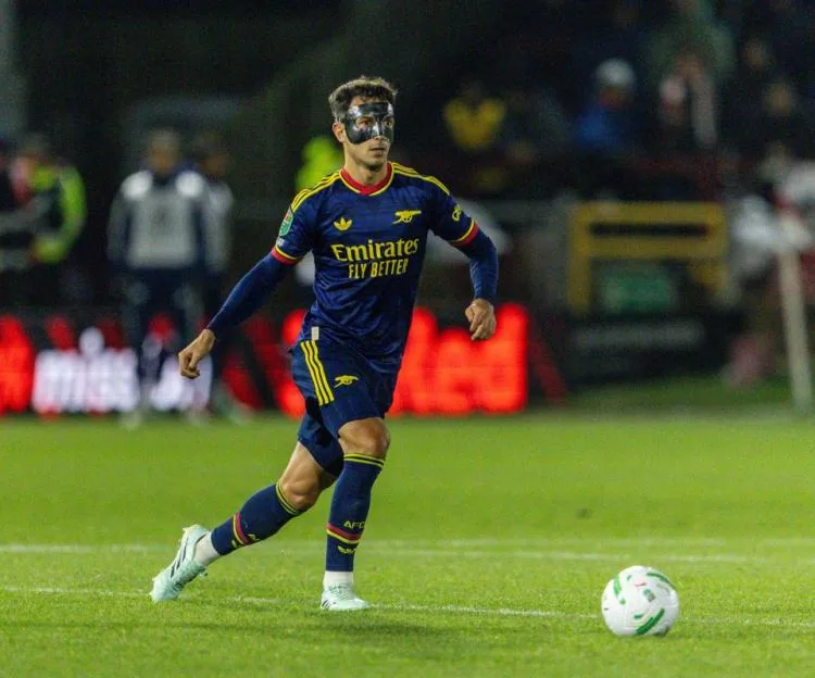 Martin Zubimendi wearing a protective mask on the pitch during a match.