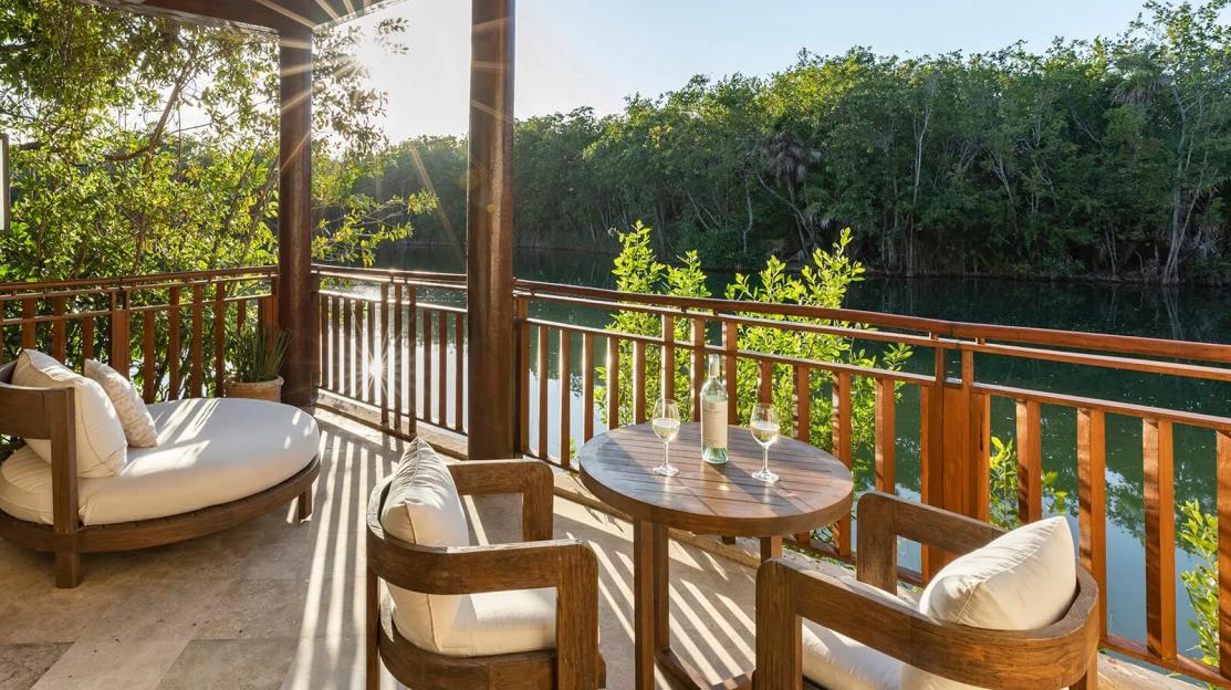 Balcony at Fairmont Mayakoba overlooking a canal with lush trees.