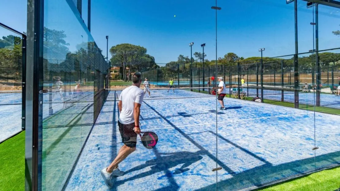 People playing padel tennis on a blue court at Quinta do Lago.