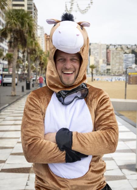 A man dressed as a horse, with goggles, smiling at the camera on a street in Benidorm.