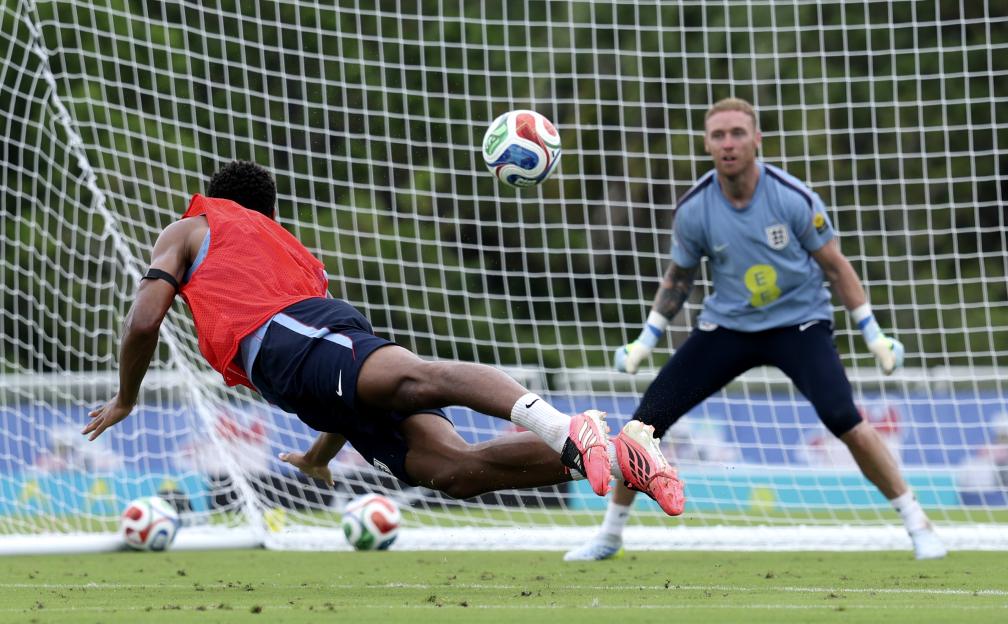 Jude Bellingham attempting to head the ball towards the goal while a goalkeeper watches from behind.