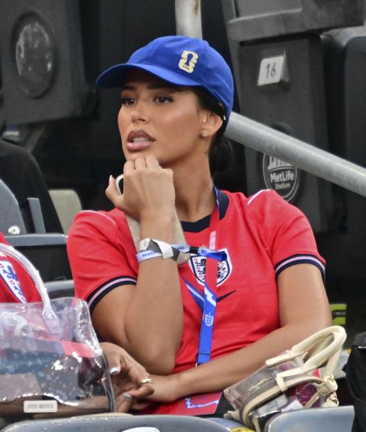 Jude Bellingham's girlfriend, Ashlyn Castro, wearing an England national football team jersey and a blue FIFA World Cup 2026 cap.