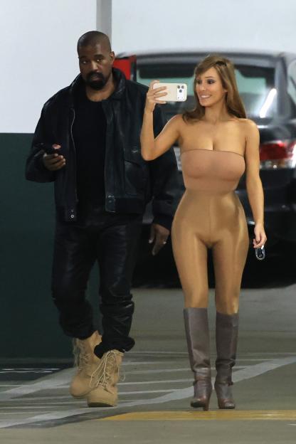 Kanye West in a black leather jacket and Bianca Censori in a nude bodysuit and tall boots walk to their car in Los Angeles.