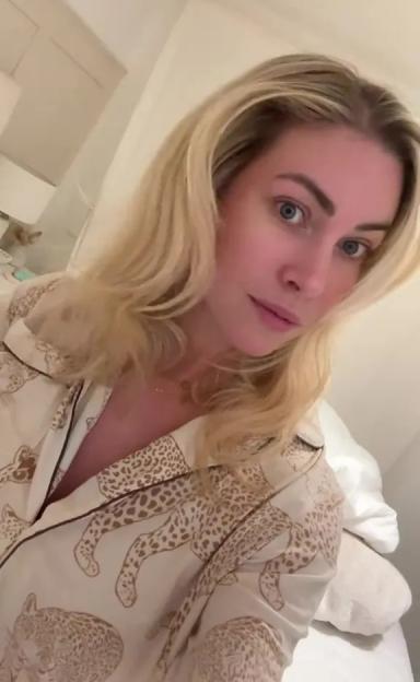 A woman with blonde hair wearing a cream-colored pajama top with leopard print pattern.