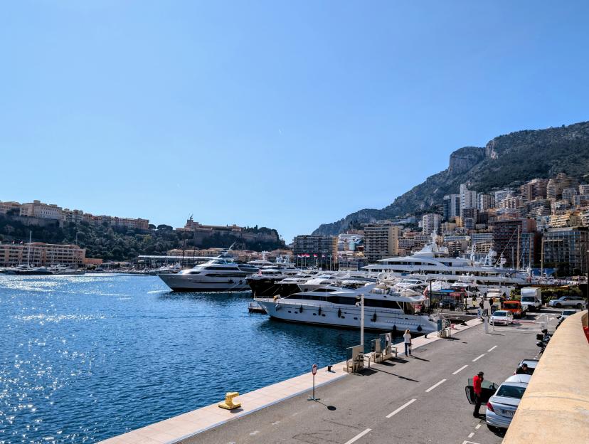 Aleksander Sikora's trip to Monaco, featuring boats in the harbor with buildings on hills in the background.