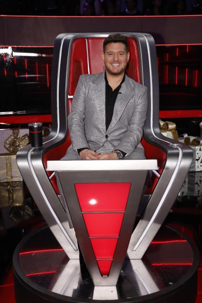 Michael Bublé sitting in a red and gray judge's chair on "The Voice."