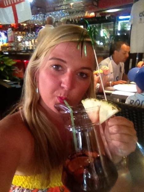 Marnie Dillon drinks from a large glass of sangria with a slice of pineapple.