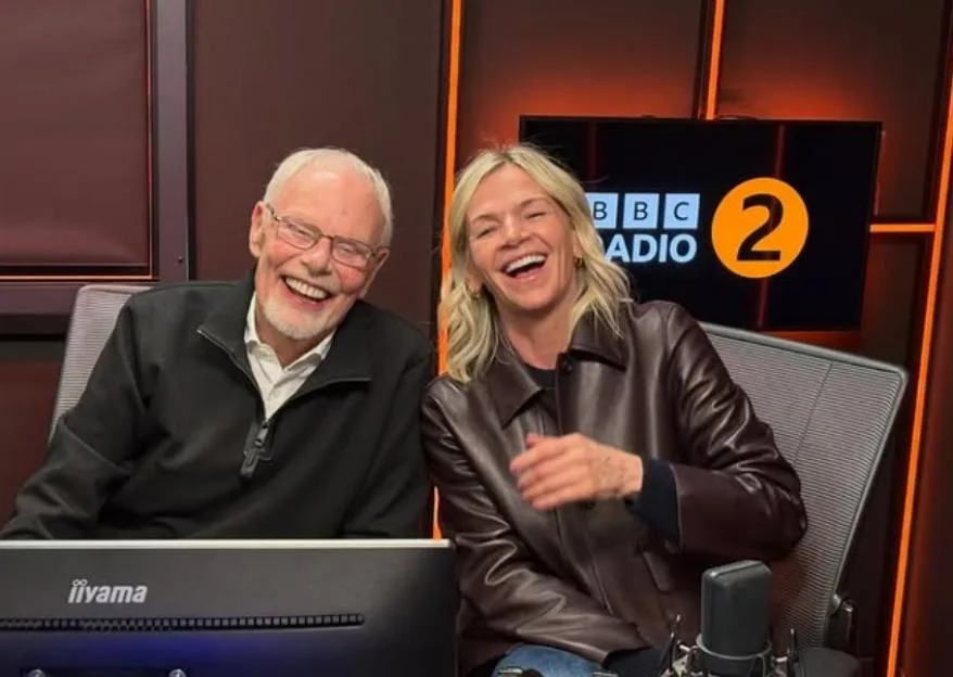 Bob Harris and Zoe Ball laughing in a radio studio.