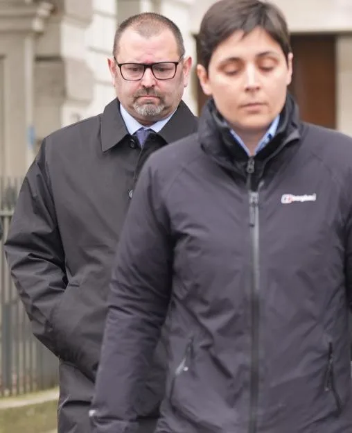 Two police officers leaving a courthouse.