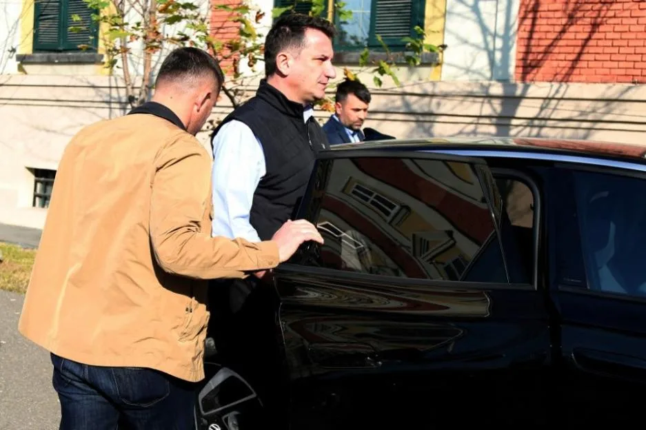 Erion Veliaj, mayor of Tirana, entering a car while accompanied by security.