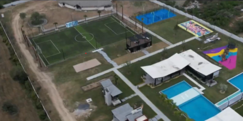 Aerial view of a recreational complex with a soccer field, tennis courts, and swimming pools.