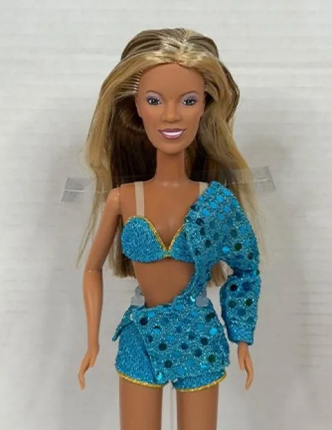 A Beyoncé doll wearing a blue sequined two-piece outfit with one long sleeve.